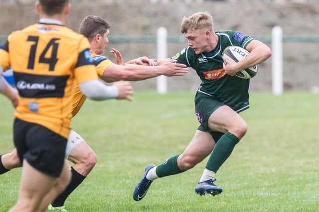 Hawick's Logan Gordon-Woolley fending off a Currie challenge at the weekend (Photo: Bill McBurnie)