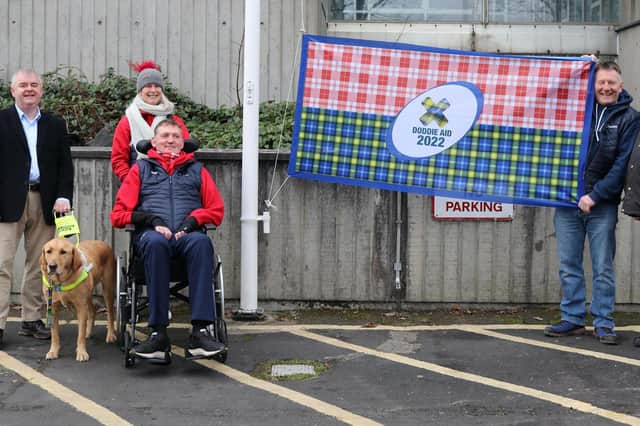 Scottish Borders Council convener David Parker, Doddie Weir and wife Kath and Gary Armstrong raising a flag for Doddie Aid at the authority's headquarters (Photo: Scottish Borders Council)