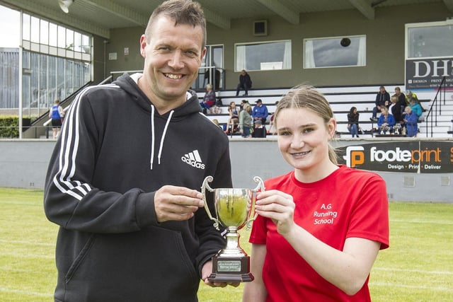 Colin Welsh presenting Ruby Laing with one of her 100m trophies at Kelso Border Games