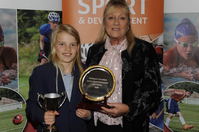 Junior sports personality award-winner Cali Nelson being presented with her trophy by Pauline Weir