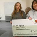 Galashiels runner Isla Paterson being given £500 by the Rowan Boland Memorial Trust's Shirley Marr (Pic: Rowan Boland Memorial Trust)