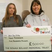 Galashiels runner Isla Paterson being given £500 by the Rowan Boland Memorial Trust's Shirley Marr (Pic: Rowan Boland Memorial Trust)