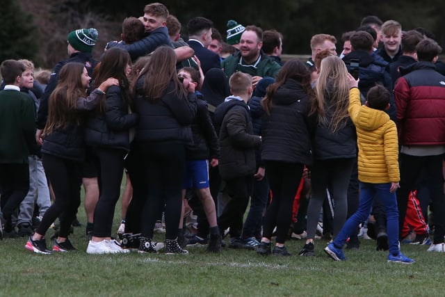 Hawick fans celebrating with players on the pitch after Saturday's 21-18 victory over Currie Chieftains