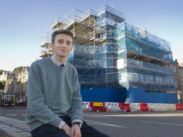 Jedburgh councillor Scott Hamilton in front of the town's scaffolding-clad building in the square.
