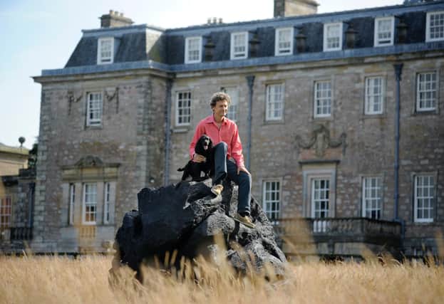 Marchmont House owner Hugo Burge with a sculpture made with burnt oak in the grounds. Photo: Colin Hattersley.