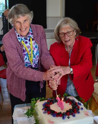 Gillian McKenzie and Matilda Hall cut the cake celebrating 30 years of the Borders Talking Newspaper.