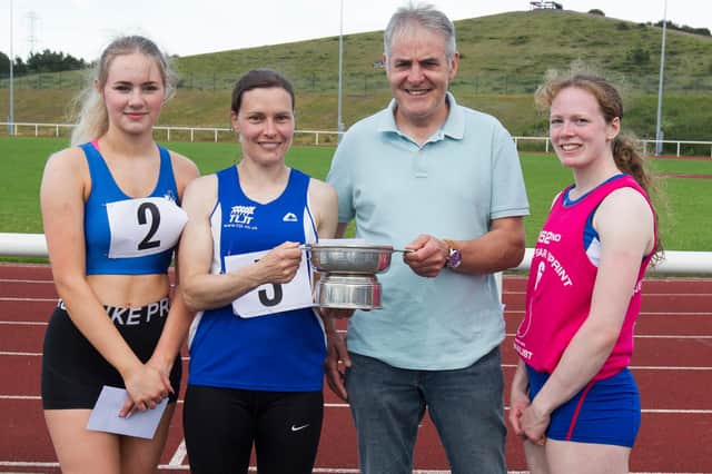 Nina Cessford, who won the Vets 90m open handicap final at Meadowmill, Prestonpans, during the 152nd New Year Sprint, is pictured with her coach Bruce Scott, flanked by fellow TLJT Club runners Brogan Beattie and Janine Boyle, right (picture by Bill McBurnie).