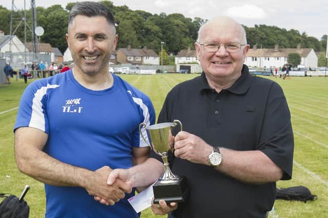 Iskan Barskanmay being given his trophy by John Hughes after winning the 200m open at Kelso Border Games on Sunday