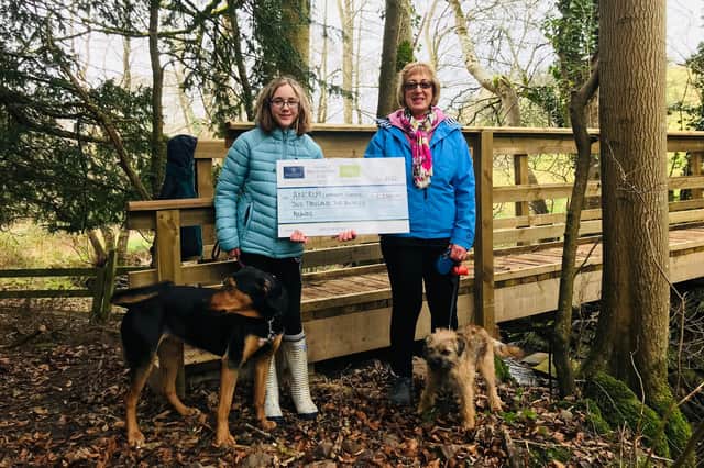 Karen Briggs from Ancrum Community Council and local resident Rosie Hunt are pictured with their dogs at the new Witch Burn Bridge, which has been constructed thanks to a grant from the Fallago Environment Fund. Photo: Ancrum Community Council.