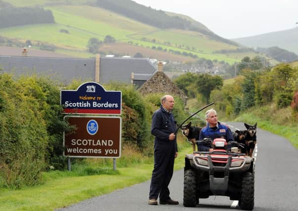 Scotsman photographer Ian Rutherford photographed English farmer Simon Orpwood (on quad bike) who's farm Bowmont hill, Northhumberland, sits on the England/Scotland border near Yetholm, chats with a Scottish neighbour Hugh Veitch a year before September's vote