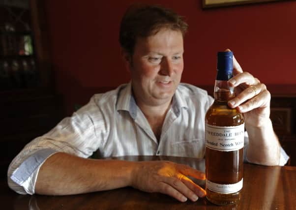 Alasdair Day with a bottle of the Tweeddale Blend whisky he has recreated from records his great-grandfather.