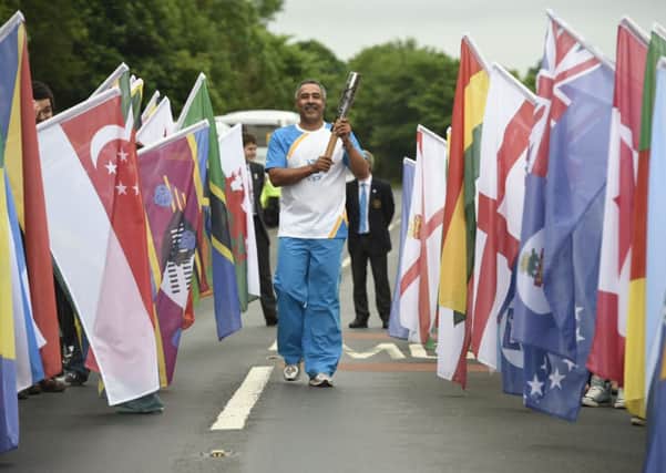 Daley Thompson carrying the Glasgow 2014 Queen's Baton across the bridge at Coldstream. Picture: Ben Birchall for Glasgow 2014/PA Wire