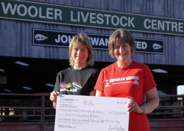 Candy Rafferty, Radio Borders Cash for Kids manager, receives a cheque for £8,716.96 from Beth Mills of Wooler Cycle Hub.