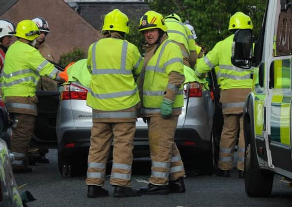 Firefighters work to free a man trapped in a car on St Boswells Main Street