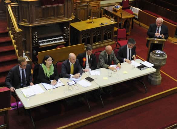 The six General Election candidates are seated at the hustings under the watchful eye of Duns Minister Stephen Blakey