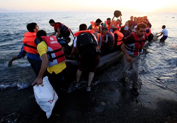 Migrants and refugees in a rubber dinghy arriving on the beach at Psalidi near Kos, Greece on their way to northern Europe. Picture: PA