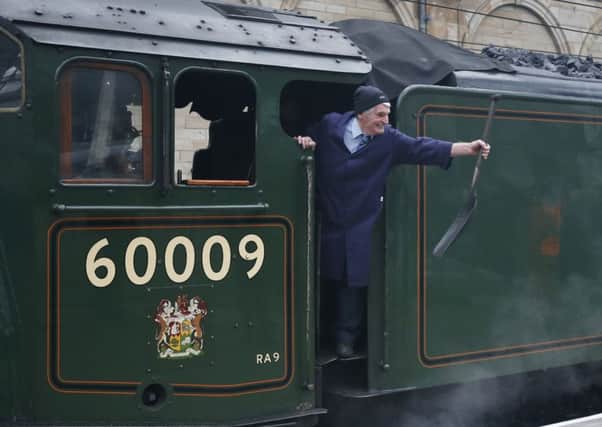 Union of South Africa owner, John Cameron,  passes a shovel from the cab of the steam locomotive at Edinburgh's Waverley station to carry Queen Elizabeth II, on the day she becomes Britain's longest reigning monarch, and her husband, Prince Philip, on a journey to inaugurate the new £294 million Scottish Borders Railway. PRESS ASSOCIATION Photo. Picture date: Wednesday September 9, 2015. See PA story ROYAL Reign. Photo credit should read: Danny Lawson/PA Wire