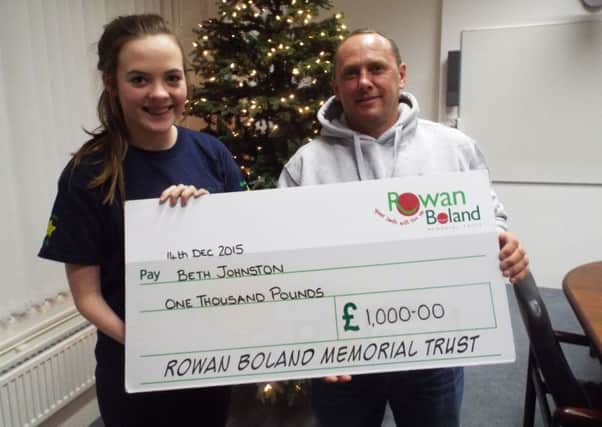 David Boland of the Rowan Boland trust hands over a cheque to disabled swimmer Beth Johnston