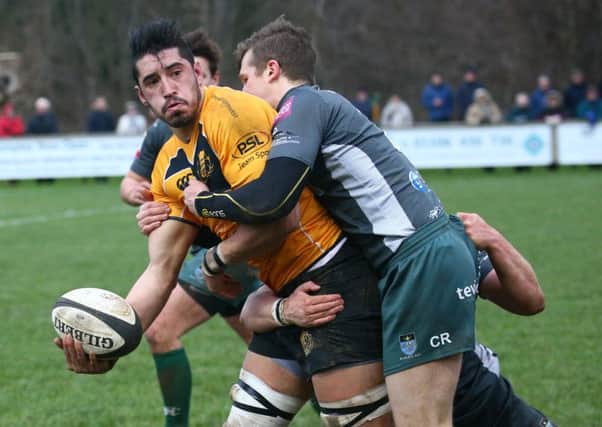 Currie flanker Travis Brooke off loads the ball despite Craig Russell's  tackle.