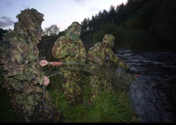 Picture  Christopher Furlong                                         
Members of a covert water bailiff team from  The Salmon Fisheries Protection Board who work under the cloak of darkness pulling in a net left by a poacher.
Furlong