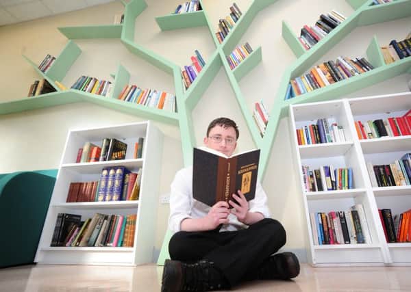 Earlston High School literacy champion Robert Miller under the tree book shelf in the new reading retreat