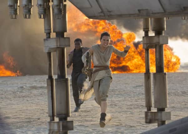 This photo provided by Disney/Lucasfilm shows Daisy Ridley, right, as Rey, and John Boyega as Finn, in a scene from the film, "Star Wars: The Force Awakens," directed by J.J. Abrams.