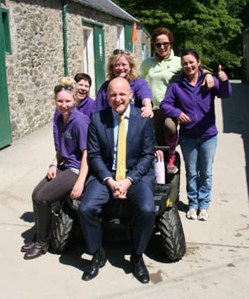 MP Calum Kerr handed over the Polaris quad bike he won in a raffle  to Stable Life manager Nicola Glendinning and the Stable Life staff.