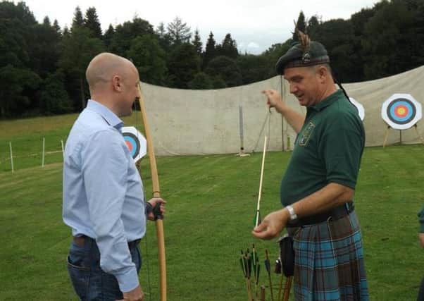 Borders MP Calum Kerr gets some tuition in the longbow from Ettrick Forest Archers chairman Doug Anderson.