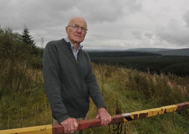 Retired Anglican priest Andrew Warburton looking over to the proposed site of a wind farm near his home near Newcastleton.