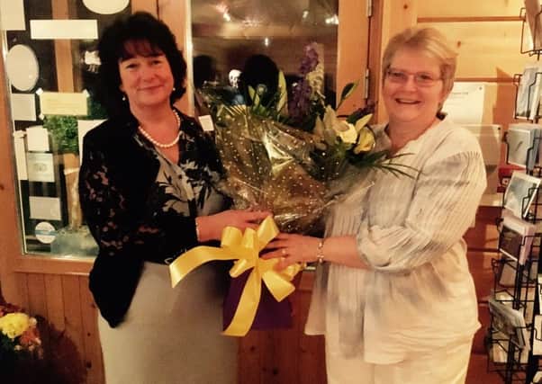 After three years as chair of Border Samaritans, Shirley Barrett receives a bouquet as thanks for her work from her successor, Lynne Hume.