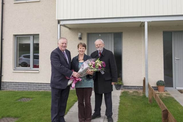 Eildon Housing Association chairman Trevor Burrows, left, and ex-chief executive Peter Lee presenting Selby Close resident Suzanne Winters with flowers to mark its official opening.