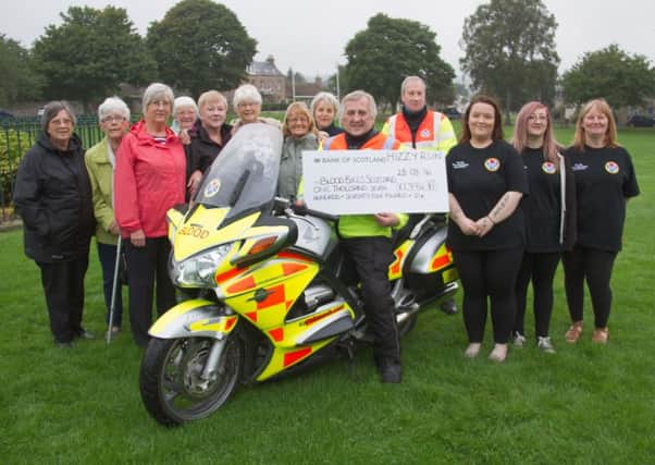 Margaret Hislop, fifth from left, at the handover of this years Hizzy Run cash to Steven Quintus, front.
