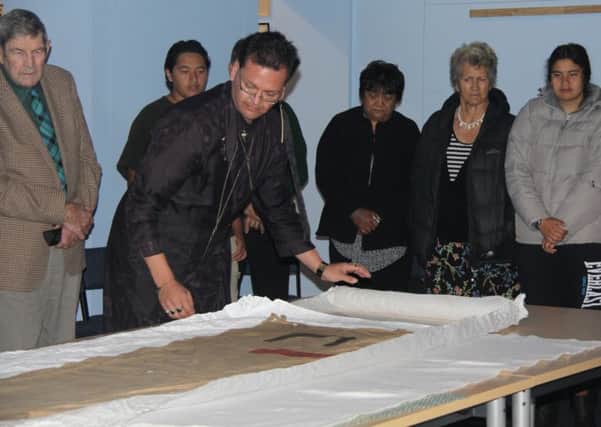Wairoa Musuem curator Nigel How reveals the Pai Marire flag after its repatriation from Hawick. Photo: Wairoa Star.