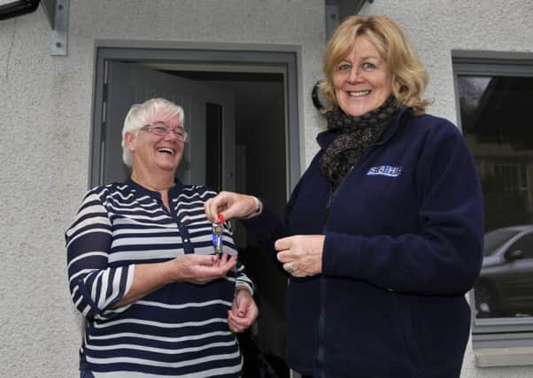 Housing association worker Elaine Brotherstone hands over the keys to Sandra McHutchison's new home in Stonefield Place in Hawick.