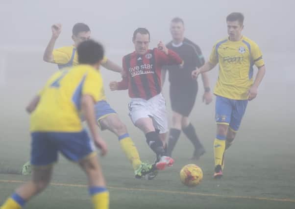 Lee Stephen of Gala FR is crowded out by yellow-clad East Stirlingshire in the ill-fated, fog-shrouded match on Saturday (picture by Brian Sutherland)
