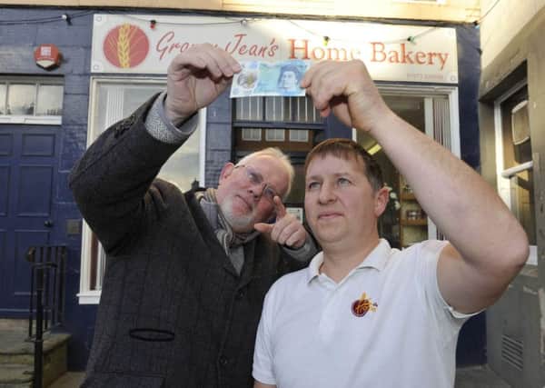 Tony Huggins-Haig and Alan Malone check a fiver outside Granny Jean's Bakery in Kelso.
