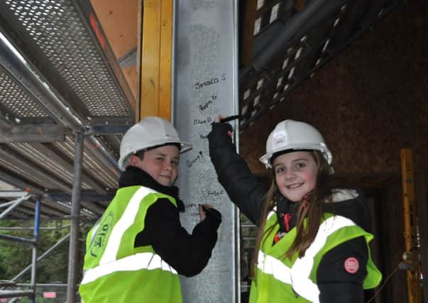 Aiden Middlemass of Stirches Primary and Ellen Dobbie of Trinity Primary add their signatures to the Wilton Lodge Park cafe structure, which will act as an alternative time capsule. The structure will be covered by cladding by contractors ESH Border Construction as progress continues on the cafe which will open in 2017.