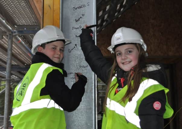 Stirches Primary School pupil Aiden Middlemass and Trinity Primary Schools Ellen Dobbie add their signatures to the framework for the new cafe in Hawicks Wilton Lodge Park.