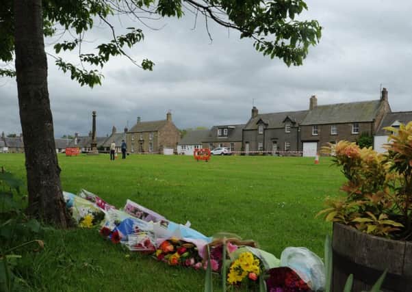 Floral tributes on Swinton village green following the death of three spectators during the Jim Clark Rally