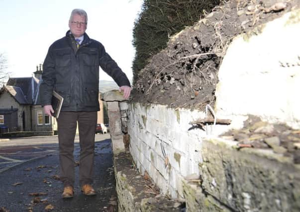 Councillor Stuart Marshall beside the collapased wall in Dickson Street, Hawick.