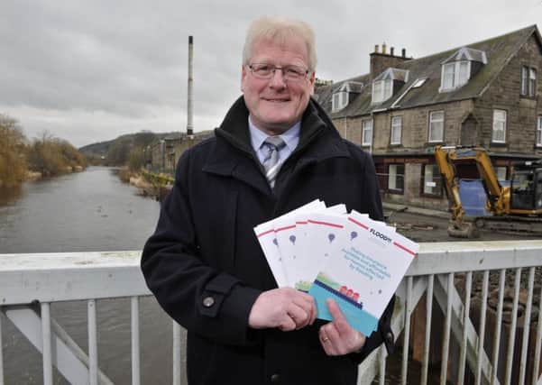 Hawick councillor Stuart Marshall in Mansfield Road, Hawick, with leaflets about flood insurance.