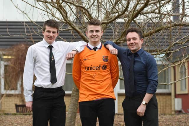 Pupils l-r, James Logan and Alistair Robinson with teacher Michael Gruba with a Barcelona FC shirt which is being given away in a raffle to raise funds for a group of pupils from Galashiels Academy to spend a fortnight in Tanzania helping build a house for the Vine Trust charity.