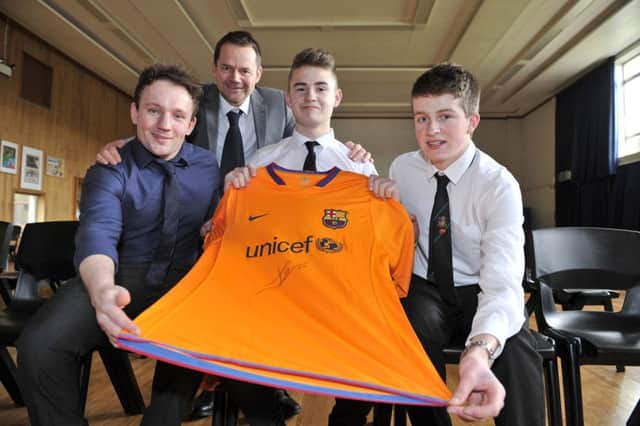 L-r, teacher Michael Gruba, headteacher Kevin Ryalls, pupils Alistair Robinson and James Logan with a Barcelona FC shirt which is being given away in a raffle to raise funds for a group of pupils from Galashiels Academy to spend a fortnight in Tanzania helping build a house for the Vine Trust charity.