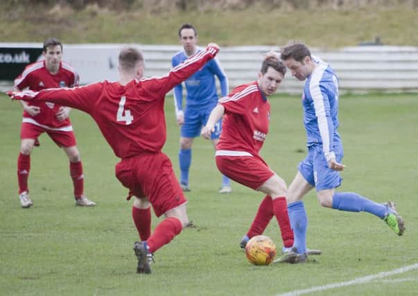 Hawick RA, in red, try to prevent Spartans midfielder David Greenhill having a crack at goal (picture by Bill McBurnie)