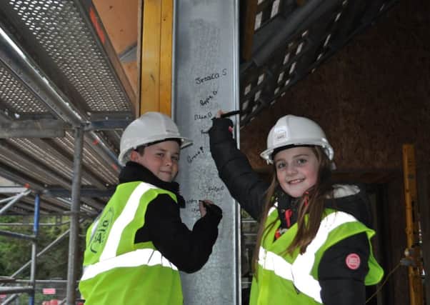 Youngsters Aiden Middlemass and Ellen Dobbie adding their signatures to the Wilton Lodge Park cafe structure as an alternative to a time capsule.