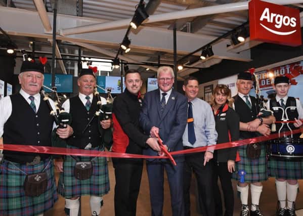 Hawick councillor Stuart Marshall opens the new Argos in Sainsburys along with store managers Jamie Easton of Argos and Rick Martin of Sainsburys, plus Hawick Scout Pipe Band.
