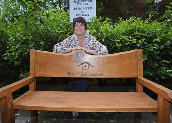 Caroline Wilkinson, president of the Bright Eyed Daughters with the group's wooden bench.