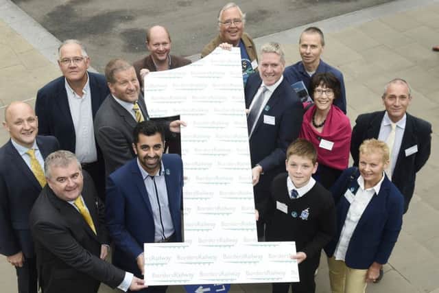 Scottish Government transport minister Humza Yousaf, seen here centre left at the front, celebrating the Borders Railways first birthday in September with guests including Hawick youngster Jake Szoneberg, front centre right, is being urged to heed calls to have it extended to the south west.