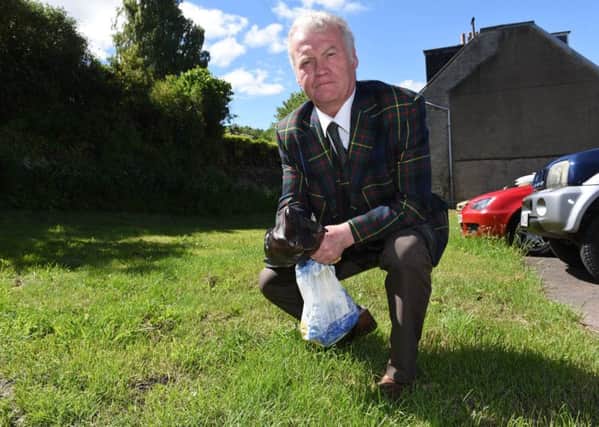 Hawick councillor Davie Paterson picking up dog dirt in Melgund Place.
