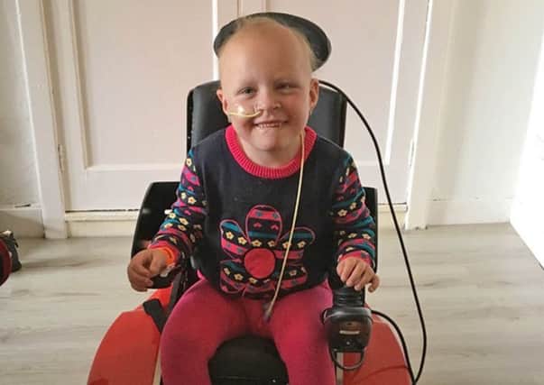 Natalya Anderson, five, in an electric wheelchair.